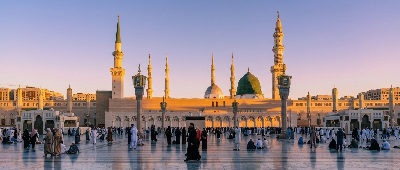 Al-Masjid an-Nabawi (The Prophet's Mosque) in Madinah at golden hour, with the green dome and minarets rising above the plaza.